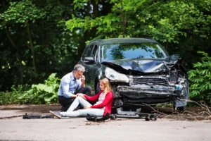 man helping injured woman after car accident