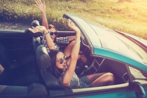 Two attractive young women in a convertible car